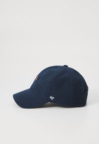 Marineblauwe corduroy pet met een gebogen klep, voorzien van geborduurde details aan de voorkant en zijkant, textuurstof en ventilatie-ogen.
