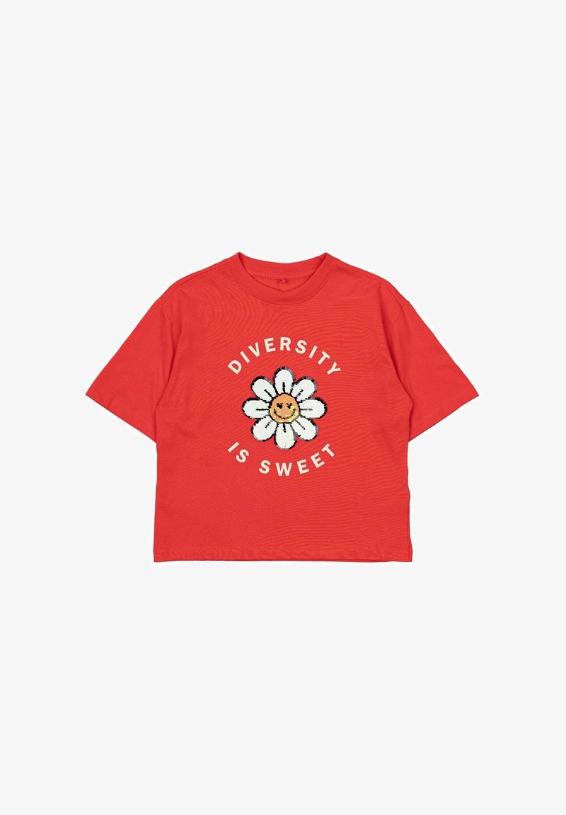 Raudona medvilninė marškinė su trumpomis rankovėmis, puošta dideliu baltu gėlių grafiniu piešiniu ir tekstu "ĮVARIETĖ YRA SALDI" balta spalva aplink jį.