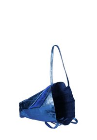 Blauwe tas met een textuur en een metallic glans, voorzien van een driehoekige vorm, twee schouderbanden en een open bovenkant met binnenvoering.