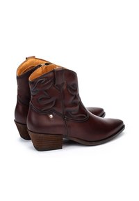 Botas de cuero marrón hasta el tobillo con punta afilada y costuras decorativas, que cuentan con una cremallera lateral y un tacón de madera texturizada.