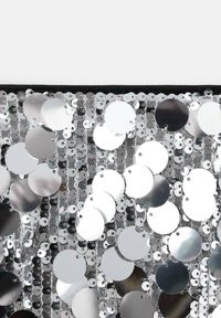 Silver sequin fabric featuring circular sequins of varying sizes, arranged closely on a mesh background, with a smooth, reflective surface.