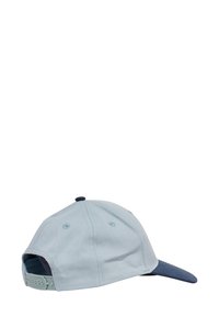 Ljusblå keps med mörkblå skärm, gjord av ett strukturerat tyg, justerbart band bak och ventilationshål på sidorna.