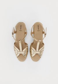 Zlaté espadrilové sandále s otvorenou špičkou, so strappy dizajnom a prackou na členku. Hladký povrch s polstrovanou stielkou.