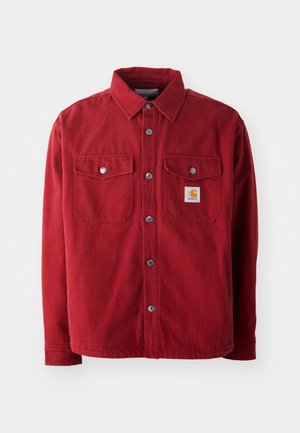 Chaqueta de camisa de algodón rojo con cuello abierto, dos bolsillos en el pecho con botones de metal y un pequeño parche de logo en el bolsillo izquierdo.