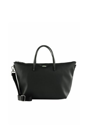 Sac fourre-tout texturé noir avec deux poignées, bandoulière détachable, ferrures argentées et petit logo crocodile vert sur le devant.