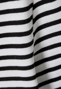 Sort og hvidt stribet stof med vandrette linjer. Teksturen virker blød og strikket, og viser jævnt fordelt striber.