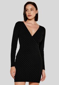 Abito lungo nero a maniche lunghe con scollatura a V profonda e motivo testurizzato. Forma aderente, tessuto morbido, lunghezza al ginocchio, senza hardware visibile.