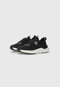 Scarpe sportive nere con design slip-on, fasce elastiche e suole bianche. Tomaia in pelle di vitello con dettagli cuciti e logo a contrasto.