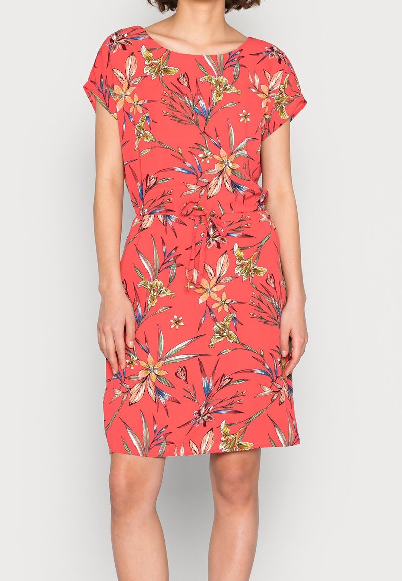 Koralfarvet blomsterkjole med korte ærmer, bindebånd i taljen, der har farverige blomstertryk i gult, grønt og blåt mod en levende baggrund.