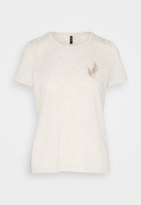 Camiseta de manga corta en color crema, hecha de tejido texturizado, con un delicado bordado de una hoja marrón en el lado izquierdo del pecho.