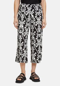 Schwarz-weiße gemusterte, kurz geschnittene Hosen mit einem fließenden Design, das einen lockeren Sitz und einen elastischen Bund für zusätzlichen Komfort bietet.