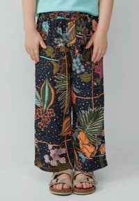 Lichtgewicht marineblau broek met bloemenpatroon, voorzien van een elastische tailleband en strikdetail, en levendige kleuren zoals oranje en turquoise.
