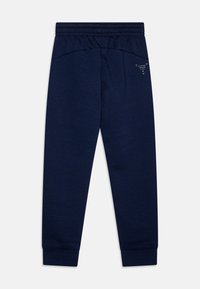 Mörkblå sweatshirtbyxor gjorda av en bomullsblandning, med en mjuk textur, elastisk midja och avsmalnande manschetter vid anklarna med subtil logodetalj.