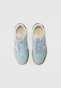Jasnoniebieskie zamszowe sneakersy z białymi i granatowymi akcentami, wyposażone w wyściełany język, klasyczny sznurowany design oraz gumową podeszwę.
