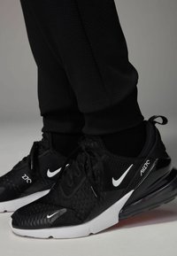 Zwarte Nike Air Max 270 sneakers gemaakt van mesh en synthetische materialen, met een witte swoosh, gestructureerde details en een zichtbare luchtunit.