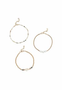 Tre braccialetti: uno con perline multicolori, uno con un accento di conchiglia e uno con perle bianche, tutti con hardware in tono oro.