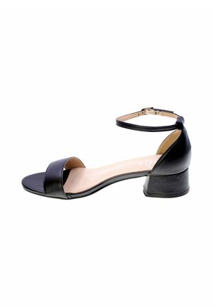 Sandalo basso in pelle nera con punta aperta, cinturino alla caviglia con fibbia e soletta beige.