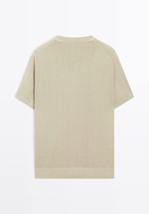 T-shirt beige a maniche corte con scollo rotondo, polsini e orlo a coste. Realizzata in tessuto liscio e leggero; design pulito e semplice.