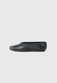 Zwarte leren ballet flats met een ronde neus en een platte rubberen zool. Een klein zilveren logo is op de hak geperst.