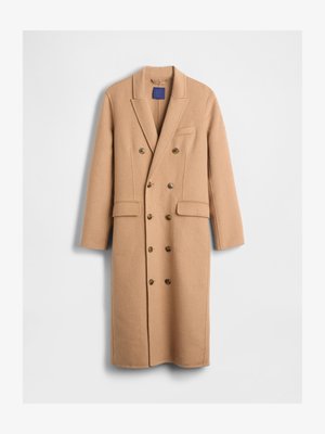Beiger Wollmischmantel mit doppelreihiger Knopfleiste, aufgeschlagenem Revers, zwei Fronttaschen und goldfarbenen Knöpfen. Mittel-langer Mantel mit glatter Textur.
