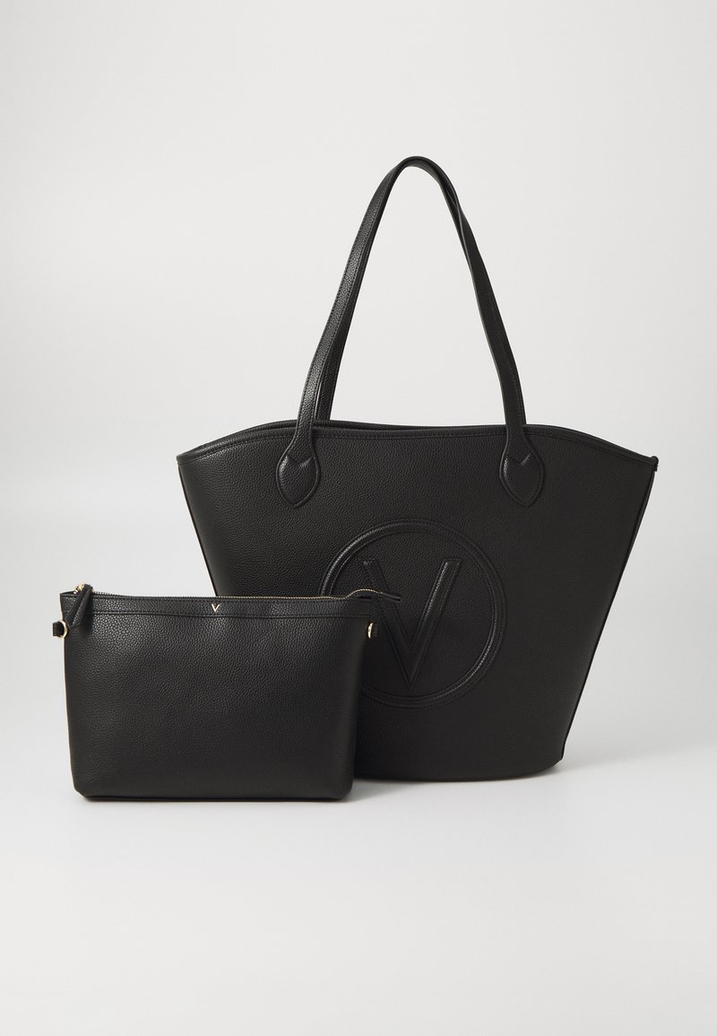 Schwarze Leder-Tote-Tasche mit geprägtem Logo, ausgestattet mit doppelten Schulterriemen und einem abnehmbaren schwarzen Reißverschlussbeutel, beide strukturiert.