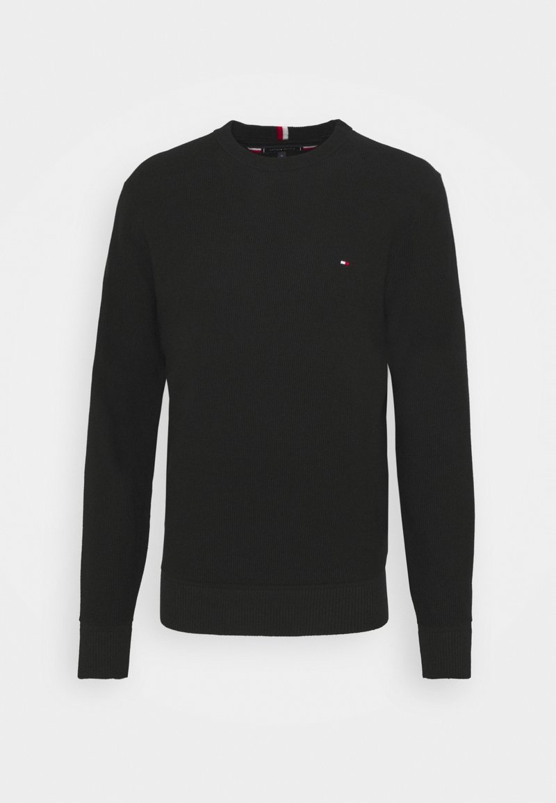 Pull noir en maille à manches longues avec col rond, poignets et ourlet côtelés, avec un petit logo rectangulaire rouge, blanc et bleu sur la poitrine.