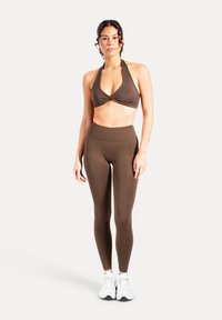 Top marrone con collo all'americana e leggings a vita alta abbinati, realizzati in tessuto liscio, con design senza cuciture e silhouette aderente.