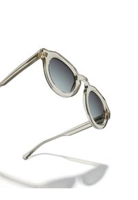 Aviator stiilis läbipaistvad heledalt hallid prillid, ümmarguste läätsedega, gradient tumedast heledaks, lai raam ja sirged käed, millel on peened tehnikadetailid.