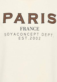 Roomkleurige sweatshirt met geborduurde tekst: "PARIS" in bruin, "FRANCE" en "SOYACONCEPT DEPT. EST. 2002" in zwart eronder.
