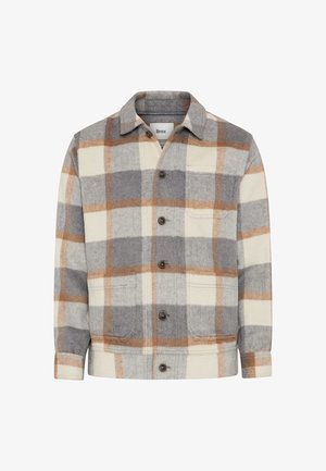 Veste à carreaux gris, crème et marron avec devant boutonné, col à revers et deux poches avant. Fabriquée en matière douce ressemblant à de la laine.