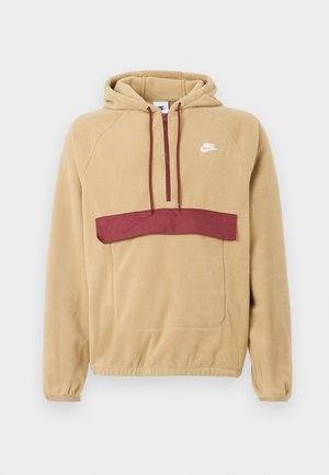 Pullover-Hoodie aus weichem, beigem Fleece mit einem kastanienbraunen Brustpanel. Er verfügt über eine Fronttasche und verstellbare Schnürzüge an der Kapuze.