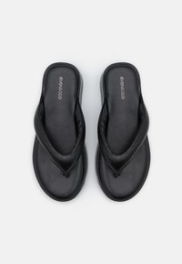 Czarne klapki z paskiem w kształcie litery V, gładką fakturą i płaską podeszwą. Logo nadrukowane na wkładce.