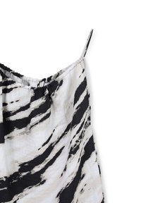 Top sans manches à motifs noir et blanc. Tissu léger et texturé avec un col élastique et des bretelles fines. Design abstrait et fluide.
