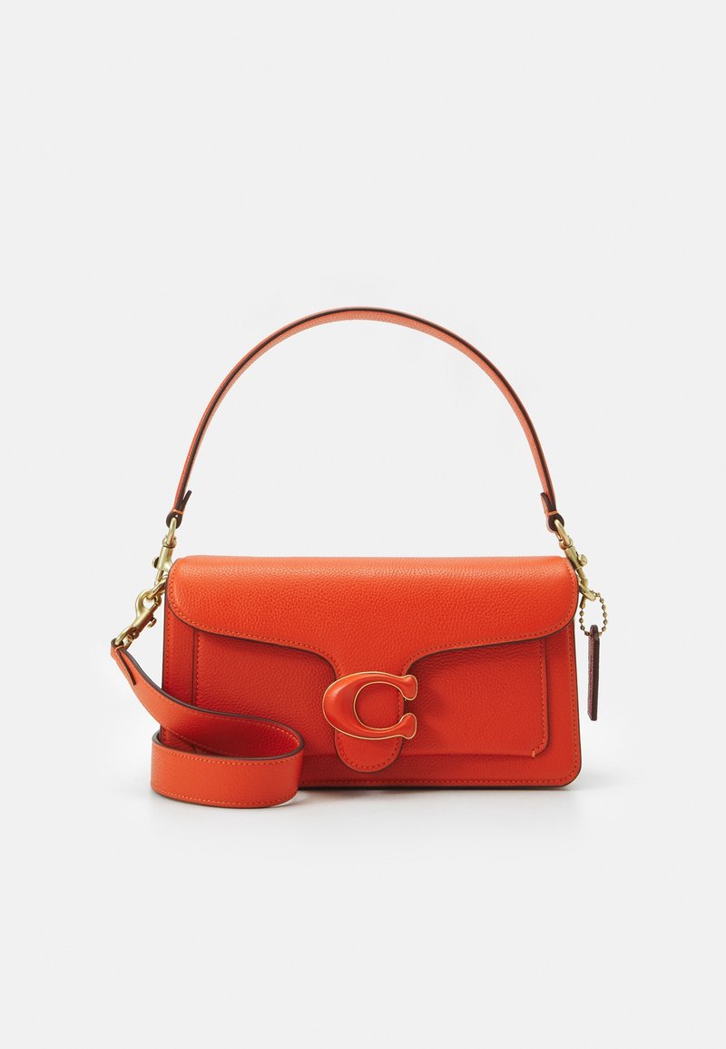 Sac à main en cuir orange avec poignée supérieure, bandoulière amovible et rabat avant sécurisé par une grande boucle en forme de C.