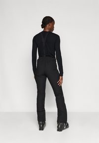 Pantaloni de schi negri cu bretele ajustabile, talie elastică și buzunare cu fermoar. Fabricati din material rezistent și rezistent la apă, ideal pentru activități de iarnă.