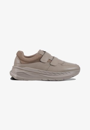 Beige sneaker with a textured leather upper and mesh accents, featuring two Velcro straps and a thick, contoured sole.