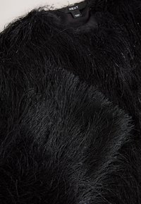 Material negro de piel sintética con textura y longitudes variadas, con un acabado brillante y ligeramente reflectante. El fondo es de un color sólido contrastante.