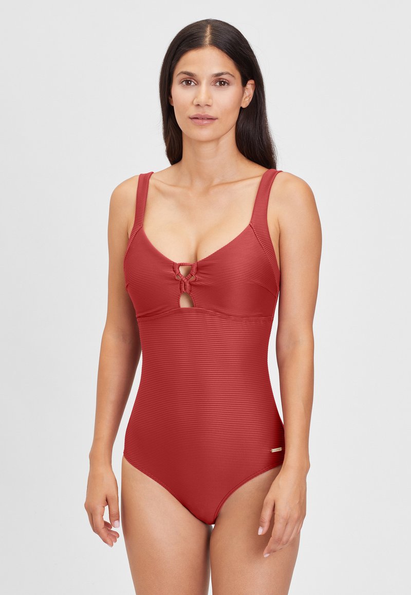 Maillot de bain une pièce rouge côtelé avec de larges bretelles, détail en trou de serrure sur la poitrine, et un petit logo. Texture lisse et design ajusté.