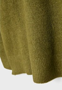 Olive green dzianina o miękkiej teksturze. Posiada prążkowany dół. Materiał wydaje się ciepły i gruby, idealny na zimową odzież.