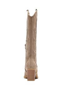 Botas de cowboy beige con diseño perforado, costuras decorativas y un tacón apilado. La vista trasera muestra costuras en ángulo y un material texturizado.