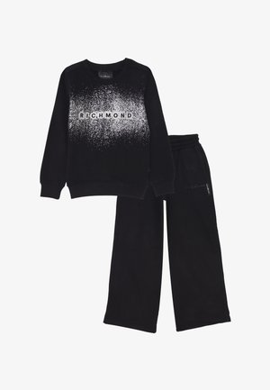 Felpa nera con motivo maculato bianco e testo "RICHMOND" abbinata a pantaloni della tuta neri a gamba ampia con cintura elastica.