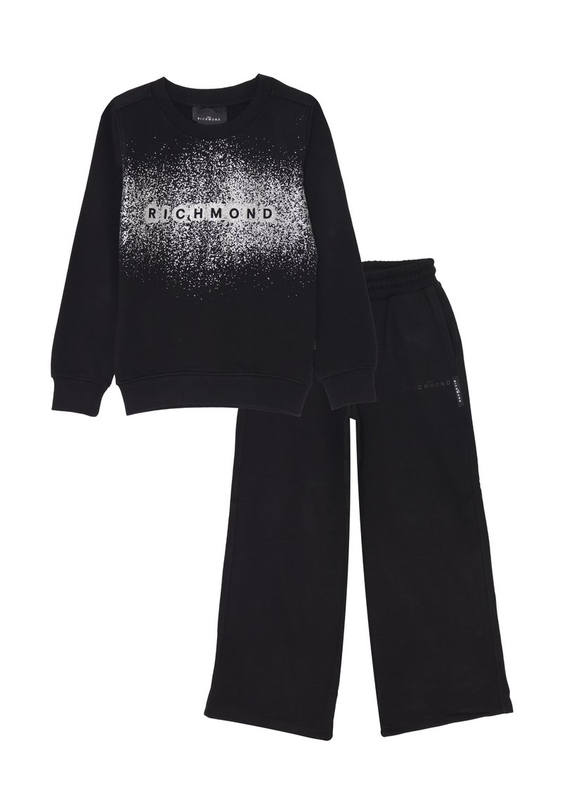 Felpa nera con motivo maculato bianco e testo "RICHMOND" abbinata a pantaloni della tuta neri a gamba ampia con cintura elastica.