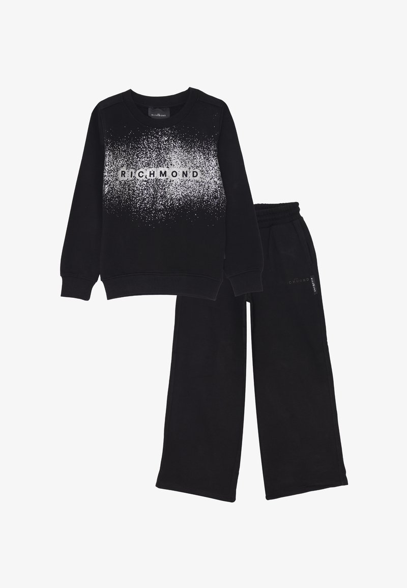 Felpa nera con motivo maculato bianco e testo "RICHMOND" abbinata a pantaloni della tuta neri a gamba ampia con cintura elastica.