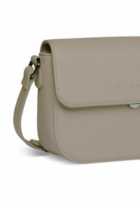 Borsa a tracolla in morbida pelle beige con chiusura a patta magnetica, cuciture in contrasto e tracolla regolabile. Presenta bordi arrotondati.