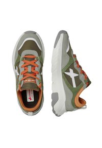 Gröna mocka- och tygsneakers med orange snören, vita accenter och texturerade sulor; rundad form och vadderad krage för komfort.