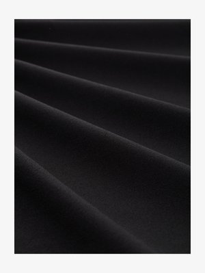 Sima fekete anyag lágy redőkkel, melyek átlós vonalakat és finom árnyékokat hoznak létre, kiemelve a textúrát és a matt felületet.