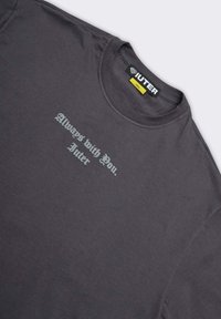 T-shirt in cotone grigio con maniche corte e collo rotondo. Presenta la scritta grigia chiara "Sempre con te. Iuter" stampata sul davanti.