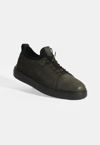 Donkergrijze leren sneaker met een ronde neus, een gestructureerd oppervlak, een zwarte rubberen zool en vetersluiting met metallic oogjes.