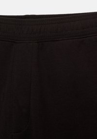 Zwarte stoffen tailleband met gedetailleerde stiksels; rekbaar materiaal voor comfort; heeft een eenvoudig ontwerp zonder patronen of versieringen.