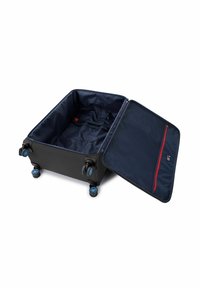 Valigia nera con ruote blu, aperta per mostrare un interno blu scuro con una tasca con zip rossa e cinghie per fissare il contenuto.